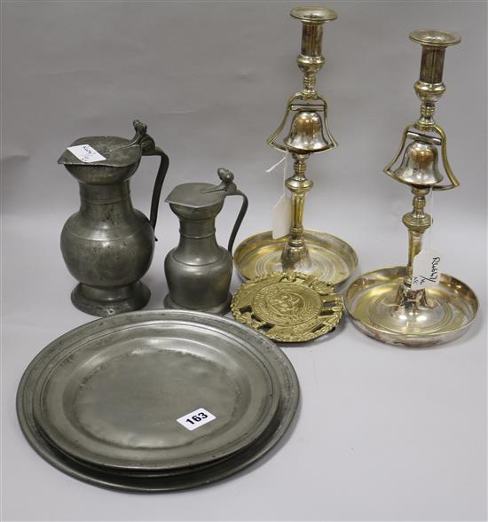 A pair silver plated brass tavern candlesticks, three pewter plates, two measures and